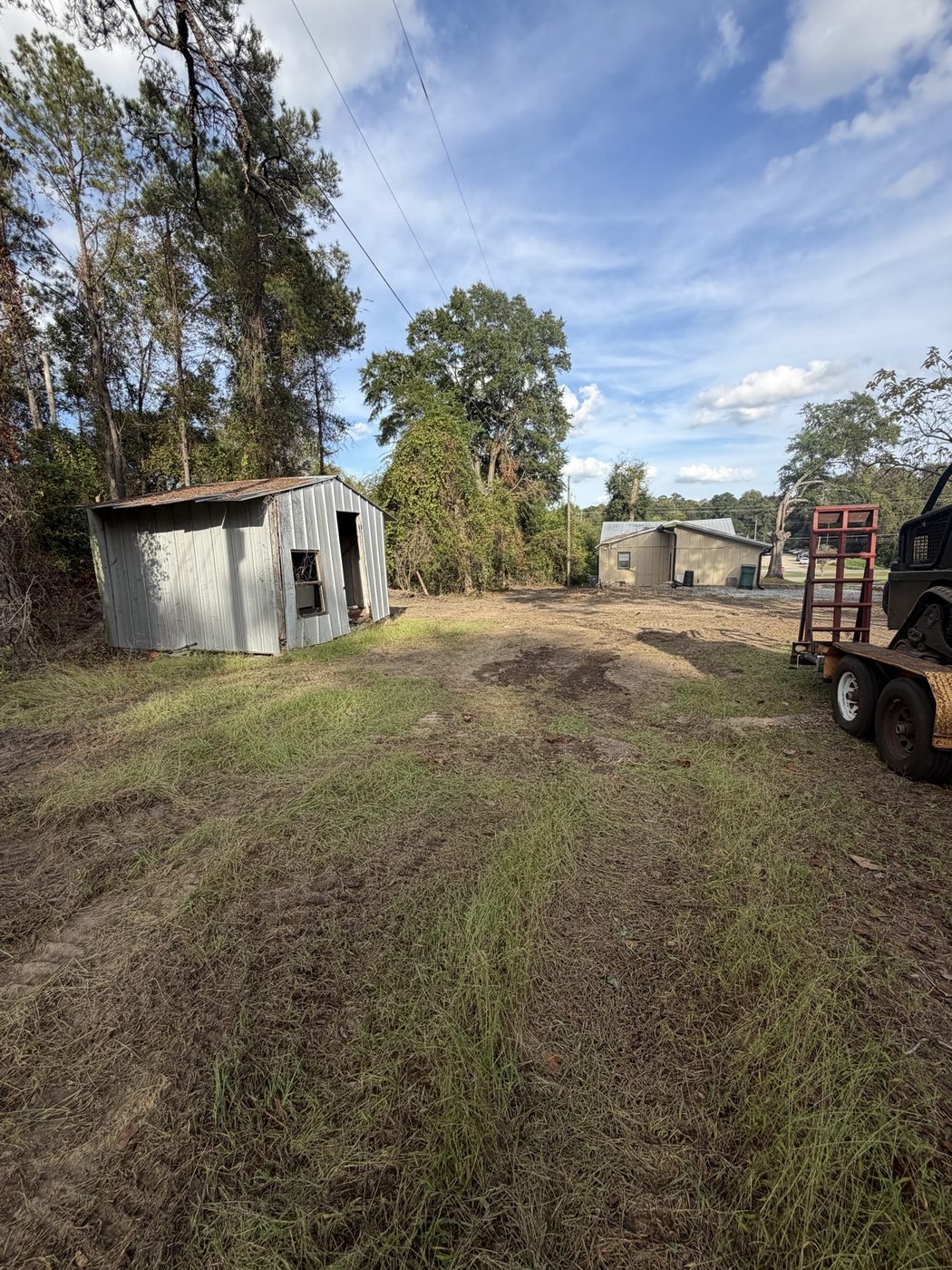 Cleared yard by the shed after debris removal