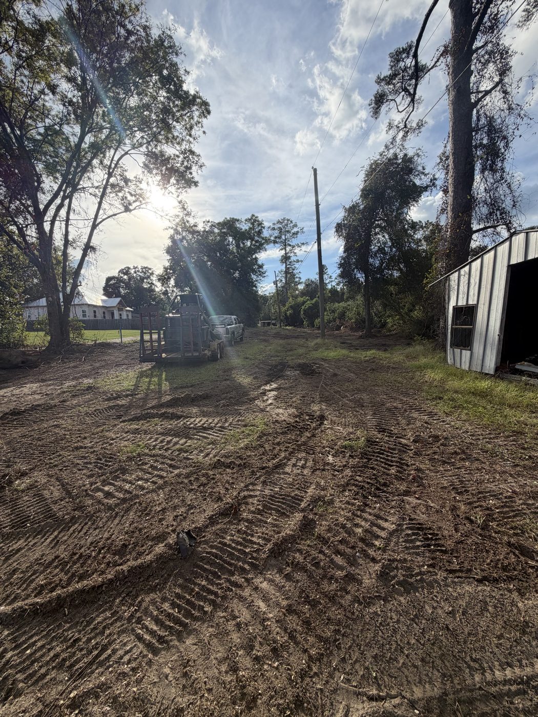 Cleared area by outbuildings with equipment on site